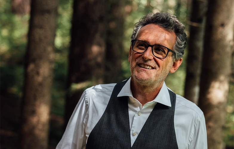 Portrait eines lächelnden Mannes vor einem Wald